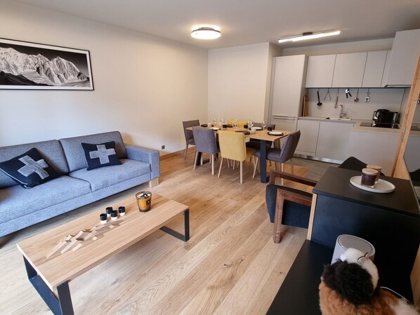 Un salon moderne avec un canapé, une table basse et un coin repas.