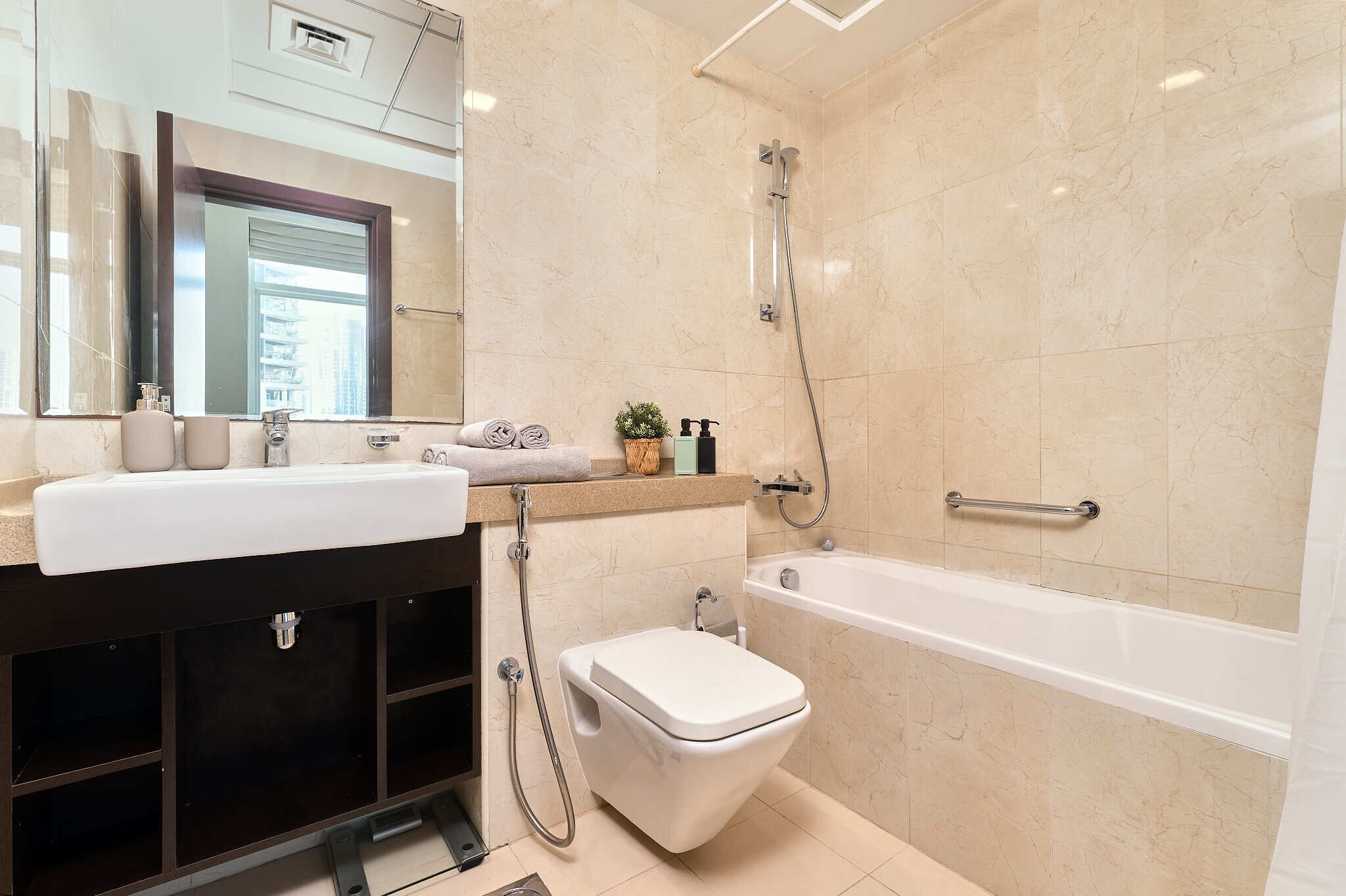 A modern bathroom with a white sink, toilet, and bathtub.