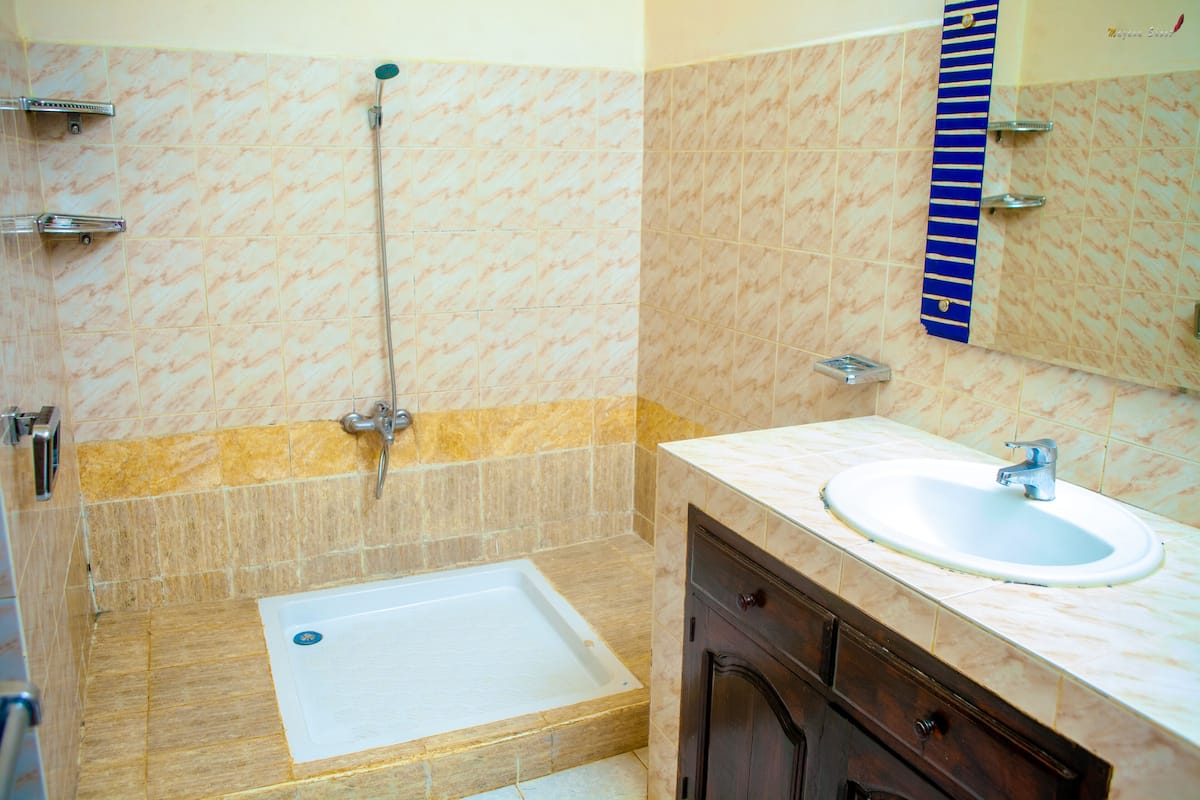 Un baño con bañera, lavamanos y espejo.