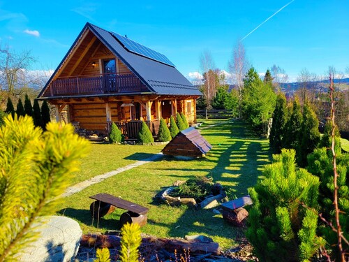 A beautiful wooden house with a sauna and jacuzzi and a large garden.