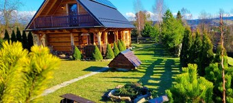 A beautiful wooden house with a sauna and jacuzzi and a large garden.