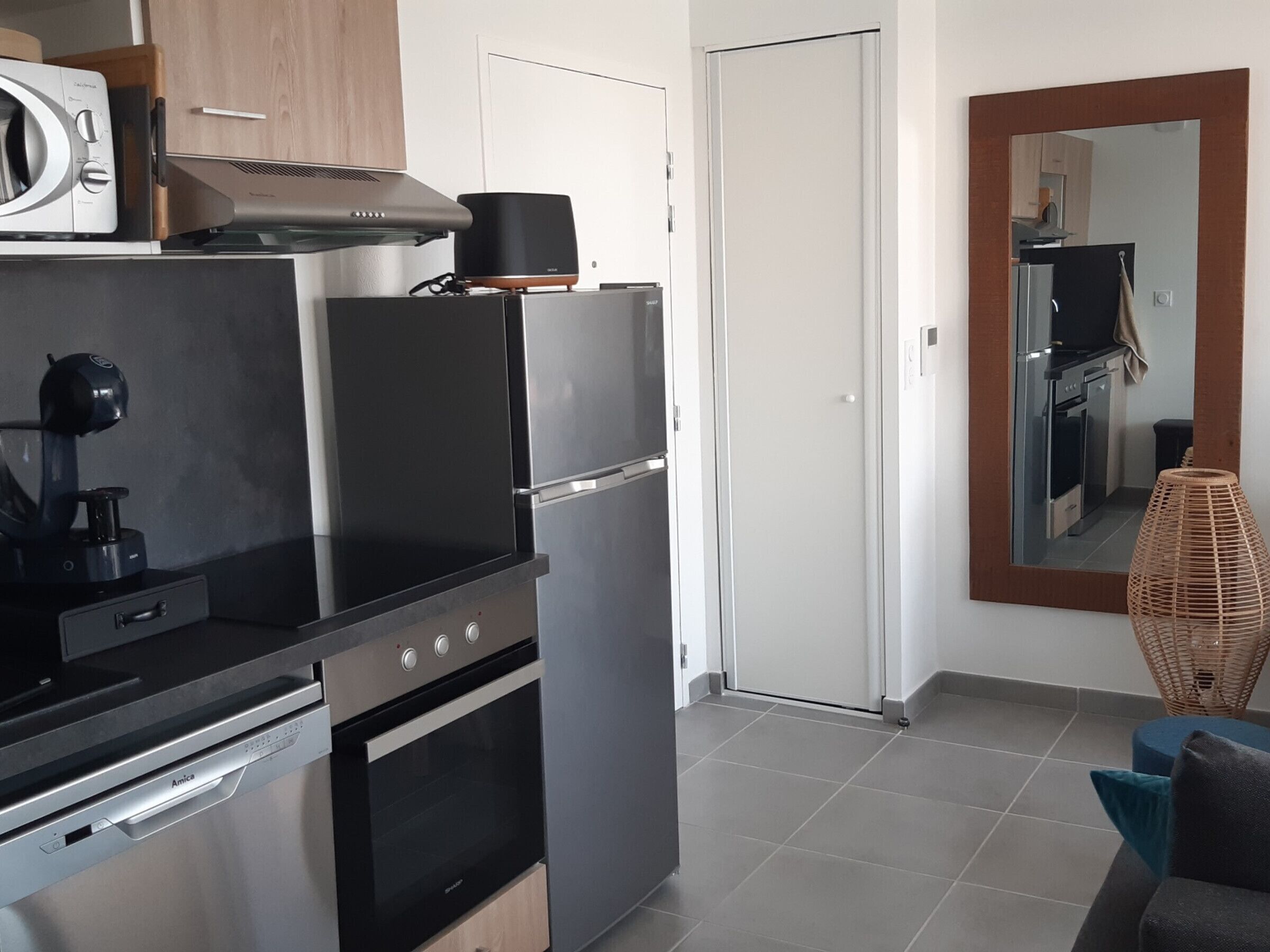 Una cocina moderna con electrodomésticos de acero inoxidable, un horno empotrado y un microondas.