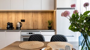 Una cocina moderna con encimera de madera, una cafetera y un florero con flores.