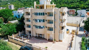 Un hôtel à plusieurs étages doté d’une cour intérieure, de balcons et de panneaux solaires sur le toit.