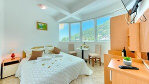 Une chambre avec un grand lit, un bureau, une chaise et un téléviseur.