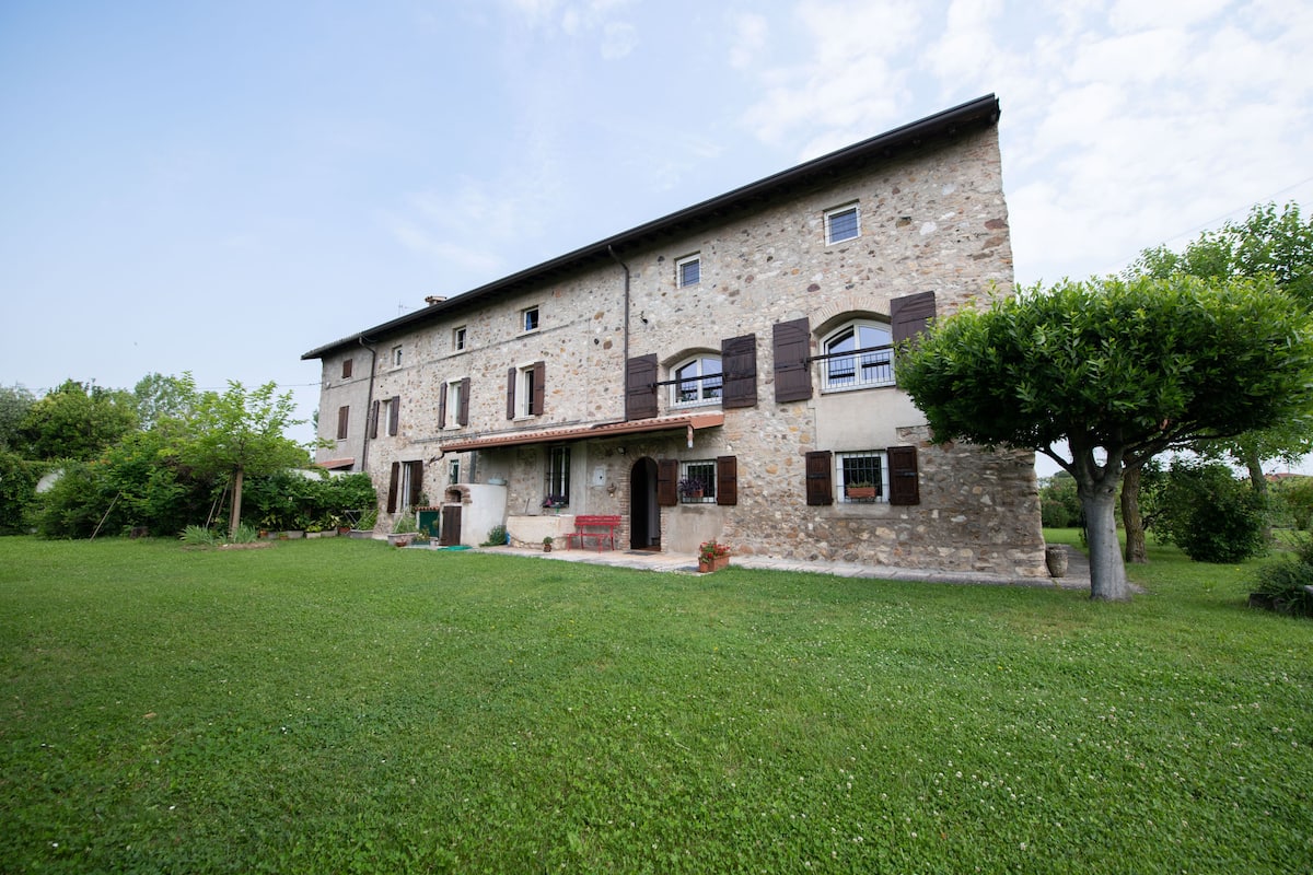 A stone building with a flat roof, multiple windows, and a front porch.