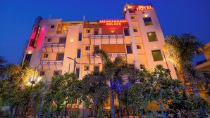 Et hotel ved navn "MEHRANGARH PALACE" med flere etager, balkoner og en veloplyst facade.
