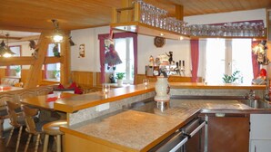 A cozy kitchen with wooden cabinets, a stainless steel sink, and a coffee machine. - Wonderful private villa for 18 people with WIFI, TV, terrace and pets allowed (Nonnenbach)