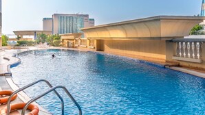 A swimming pool with a curved edge, surrounded by a concrete deck and a balustrade. - Cozy 1BR apartment Marina Crown (Dubai)
