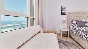 A bedroom with a large window, a bed, a nightstand, and a lamp. - Cozy 1BR apartment Marina Crown (Dubai)