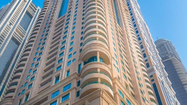 A tall, beige-colored building with multiple balconies and arched windows. - Cozy 1BR apartment Marina Crown (Dubai)