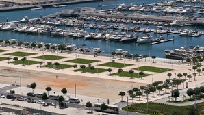 A marina with numerous boats docked, a sandy beach area, and a clear view of the ocean. - Cozy 1BR apartment Marina Crown (Dubai)