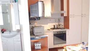 A compact kitchen with a sink, stove, microwave, and cabinets.