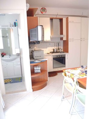 A compact kitchen with a sink, stove, microwave, and cabinets.