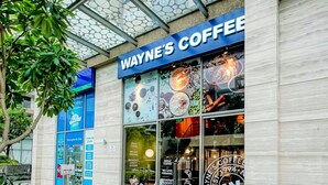 Una cafetería con escaparate de vidrio y un letrero que dice "Wayne's Coffee".