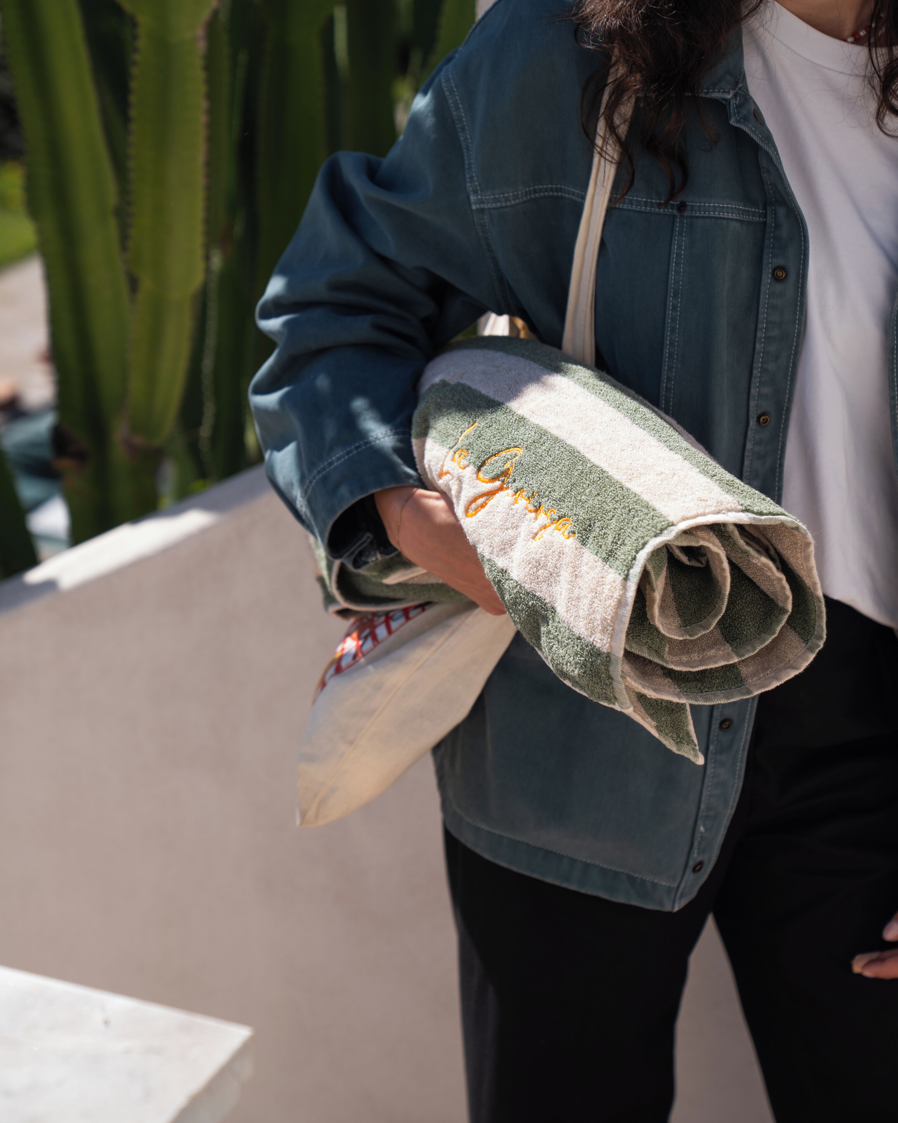 A person holding a rolled-up item with a visible pattern and text.