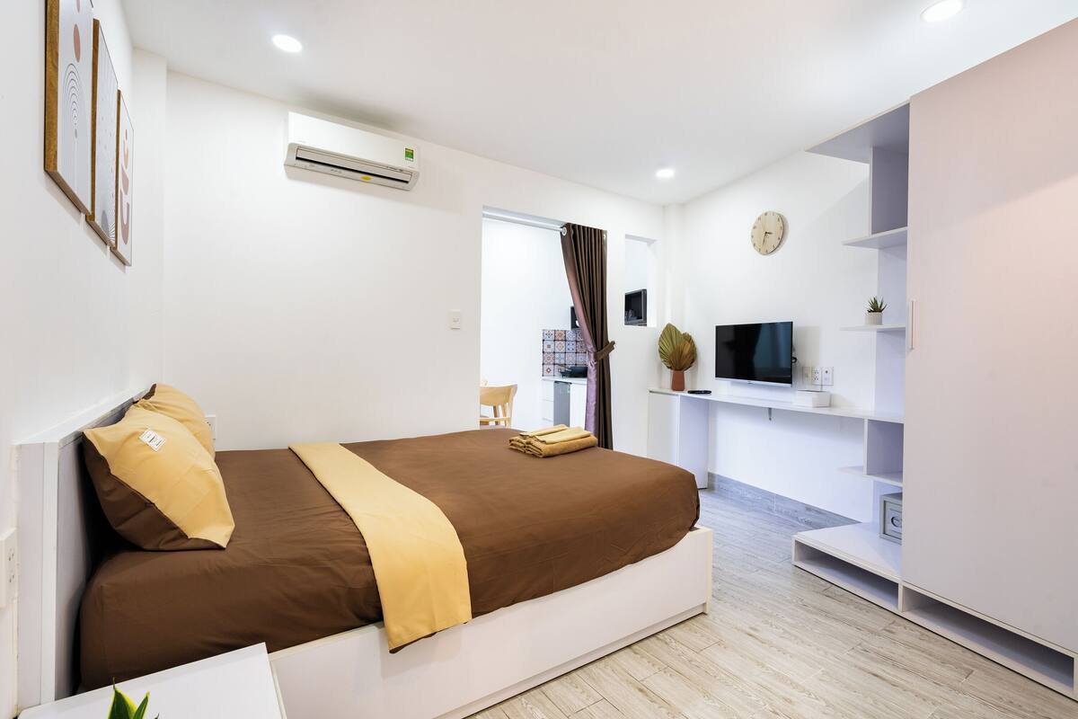 Ein modernes Hotelzimmer mit einem großen Bett, einem Fernseher und einer kleinen Pflanze.