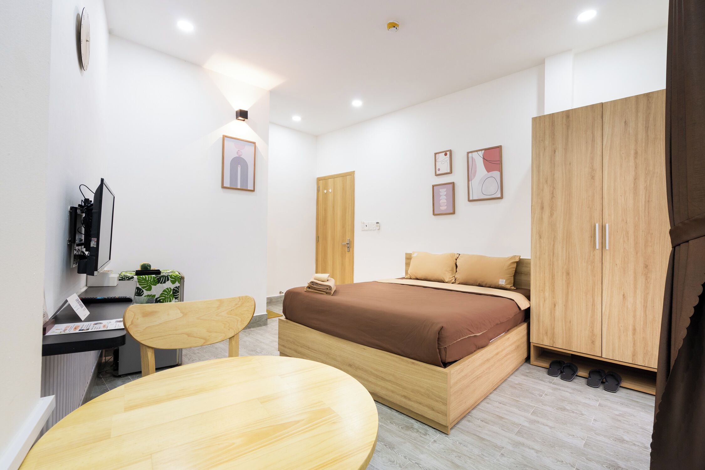 Un dormitorio moderno con una cama de madera, un escritorio, una silla y un armario.