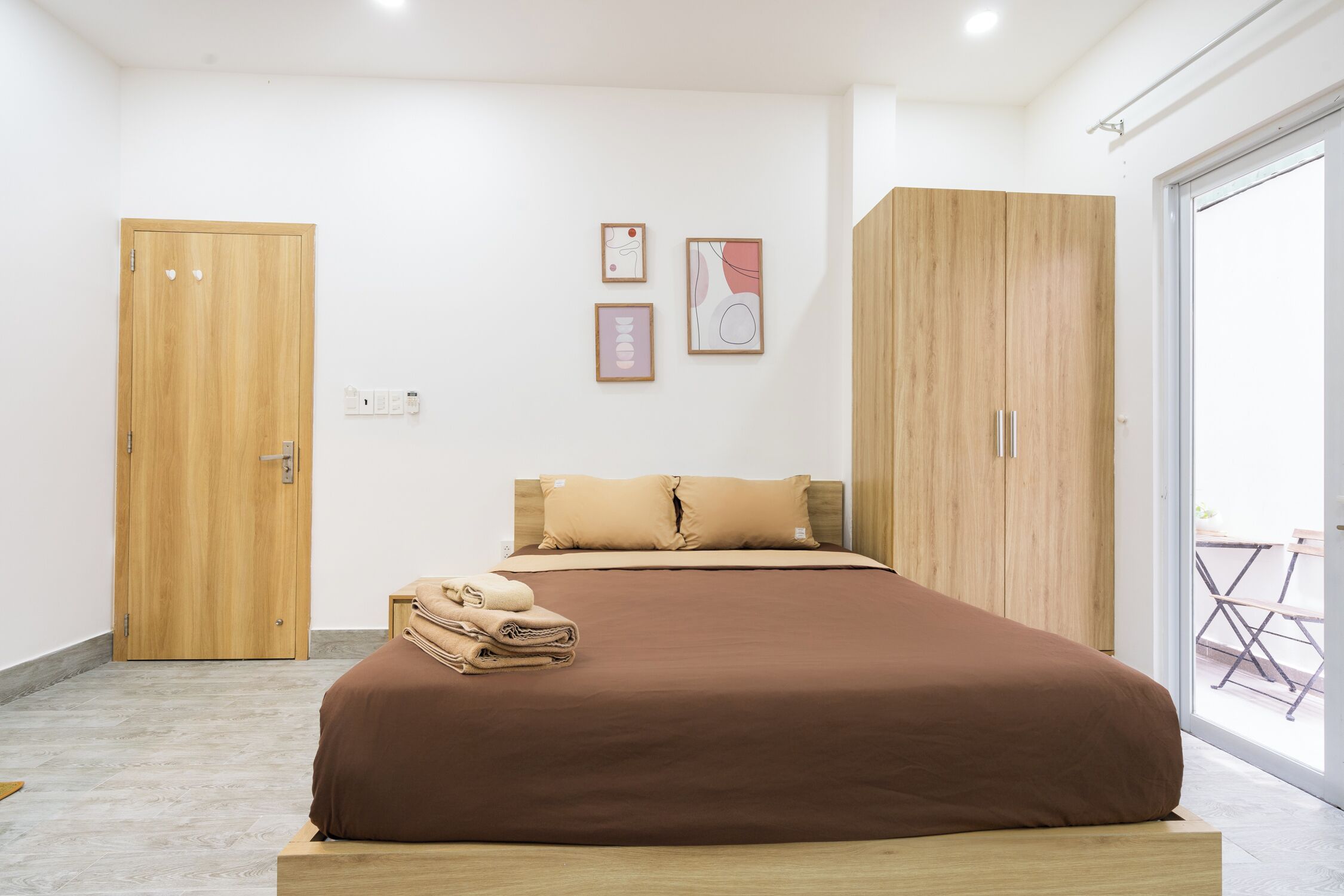 A bedroom with a bed, wooden wardrobe, and a door.