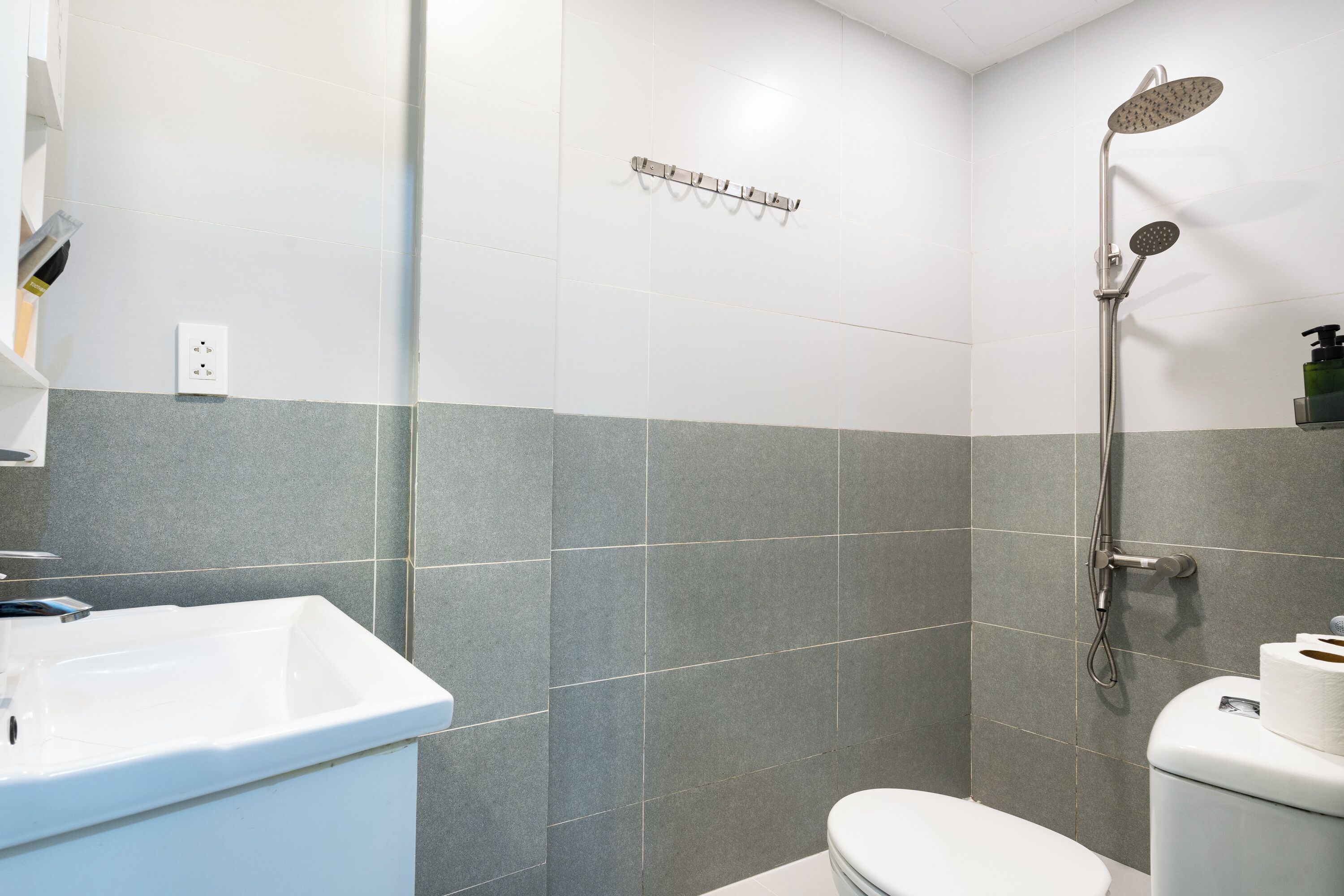 A bathroom with a shower, toilet, and sink.
