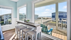 A balcony with a view of the beach and other buildings. - Oceanview Dog Friendly Home with Heated Pool and Golf Cart, 7 Green Pelicans (Oak Island)