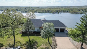 Une maison avec un garage, une allée et une vue sur le lac.