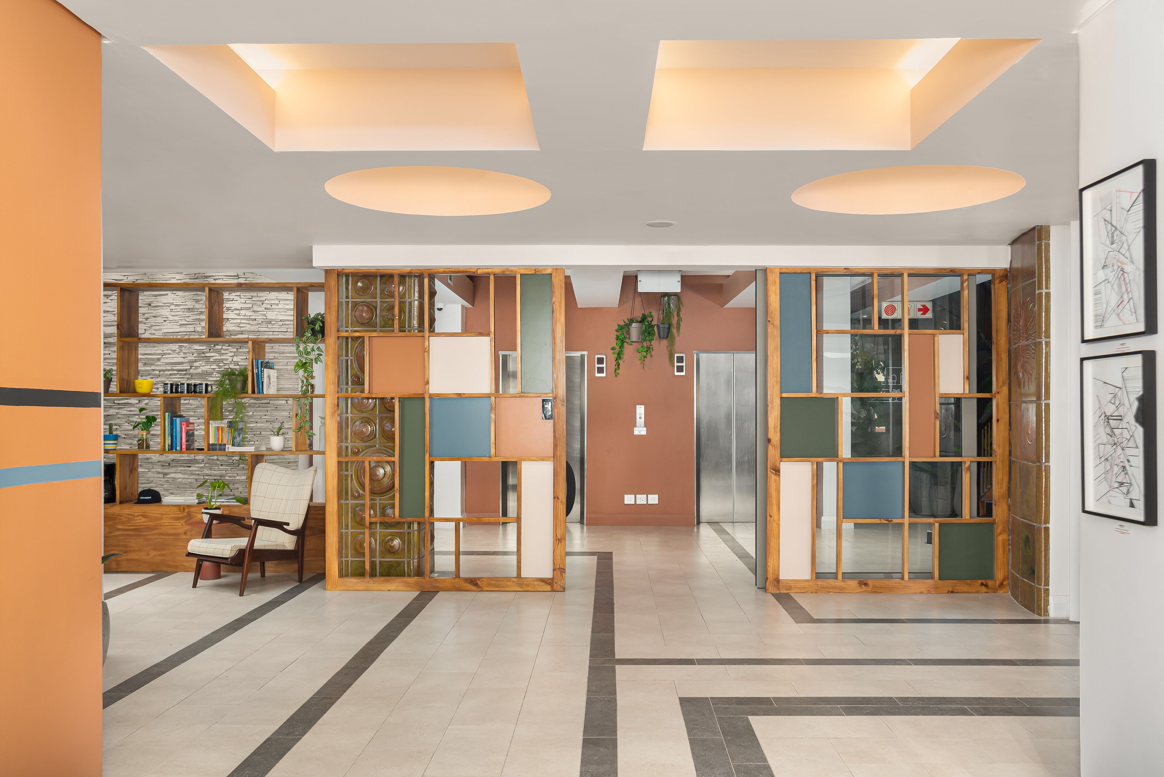 Un interior modern amb un espai central obert, separadors de fusta i una zona de seients amb una cadira.