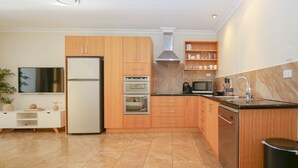 Une cuisine moderne avec des meubles en bois, un four encastré, un four à micro-ondes et un évier.