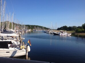 Boats docked along the water's edge, surrounded by lush greenery.