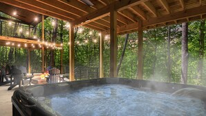 Ein Whirlpool in einem Holzdeckbereich mit Feuerstelle und Sitzgelegenheiten im Freien.