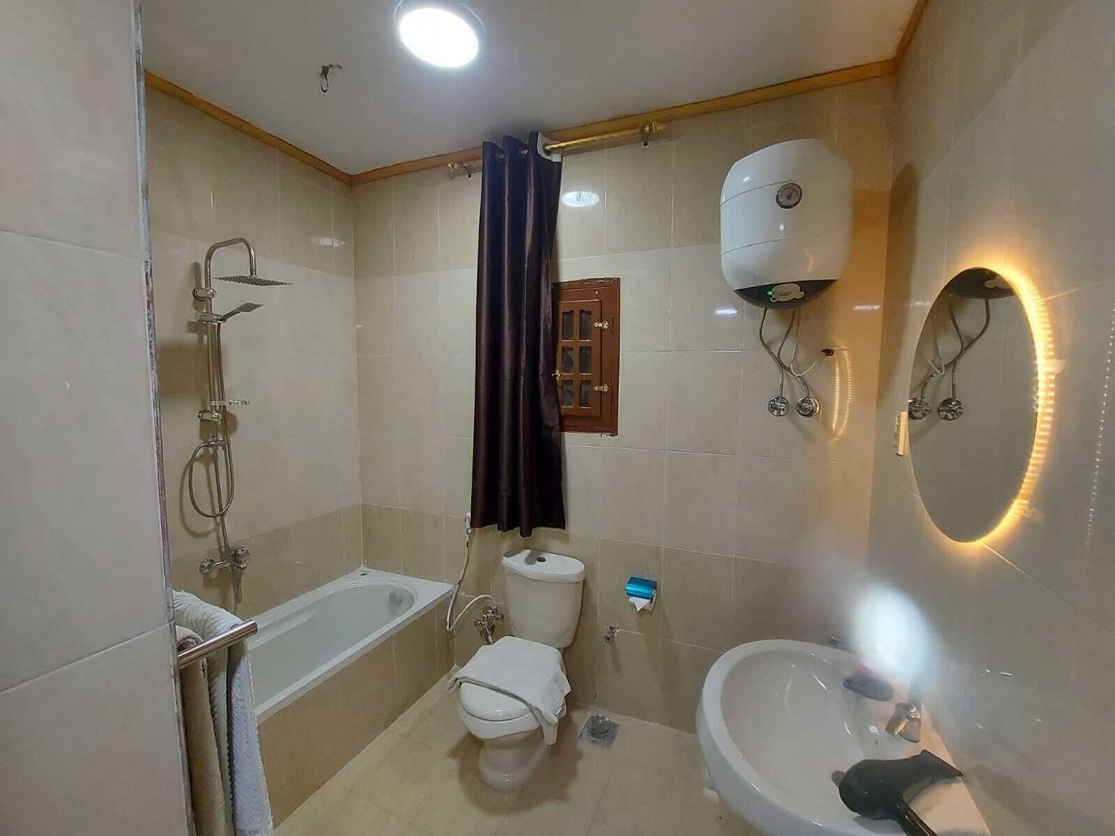 Habitación triple familiar | Baño | Bañera de hidromasaje y cabezal de ducha tipo lluvia