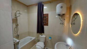 Habitación triple familiar | Baño | Bañera de hidromasaje y cabezal de ducha tipo lluvia