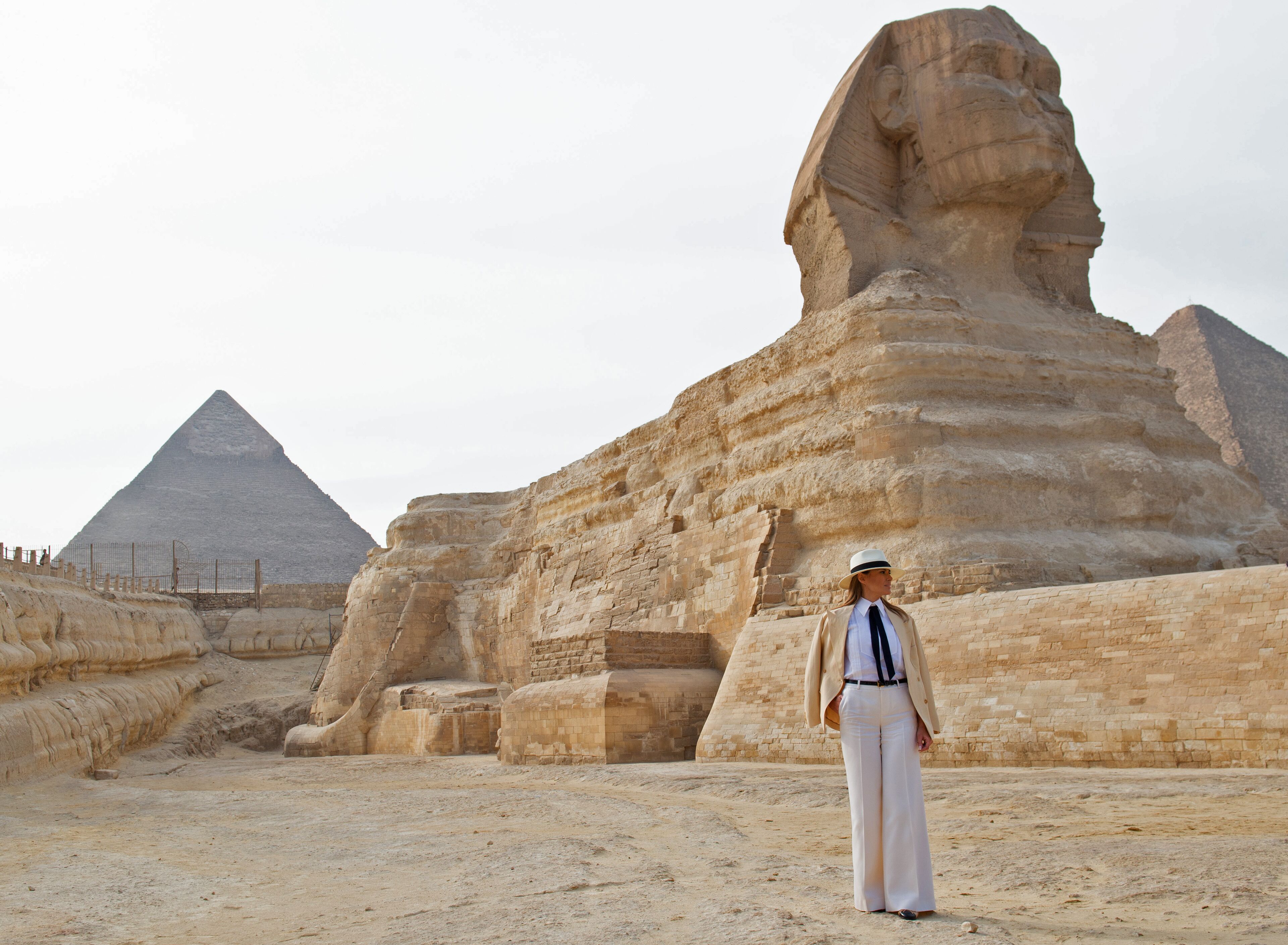 A person standing in front of the Great Sphinx and the Pyramid of Khafra in Giza, Egypt.