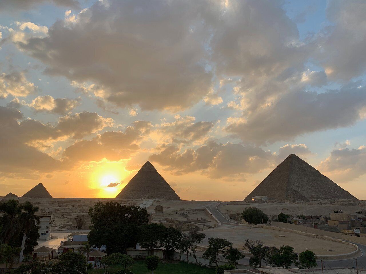A pyramid complex with a clear sky and sunset.