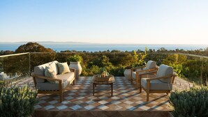 A terrace with a checkered floor, outdoor furniture, and a view of the sea. - Stunning Santa Barbara Estate (Santa Barbara)