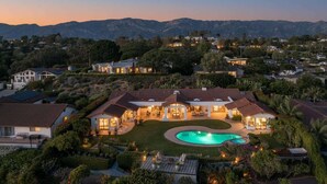 A large, two-story house with a swimming pool, surrounded by lush greenery and a mountainous backdrop. - Stunning Santa Barbara Estate (Santa Barbara)