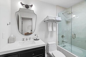 Een bad,  milieuvriendelijk toiletgerief, een haardroger, handdoeken