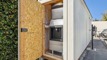 Un bâtiment moderne et compact, doté d’une façade métallique et d’une porte en bois.