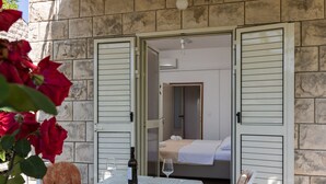 Ein Zimmer mit einem Bett, einem Tisch mit Flasche und Glas sowie einem Stuhl.