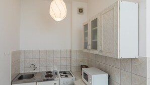 Eine kleine Küche mit Spüle, Herd und Mikrowelle.