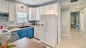 A modern kitchen with white cabinets, a built-in dishwasher, and a refrigerator. - LA CASA ROSADA ~ Perfectly Located 2 BR, 2.5 Ba Home w/ Private Hot Tub! (Key West)