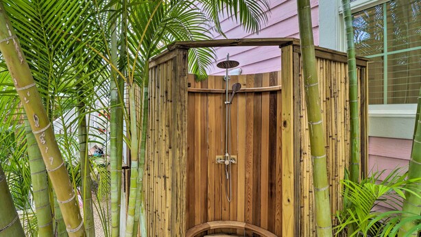 A wooden outdoor shower structure with a curved entrance, surrounded by bamboo plants. - LA CASA ROSADA ~ Perfectly Located 2 BR, 2.5 Ba Home w/ Private Hot Tub! (Key West)