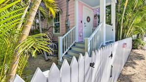 A pink house with a white porch, a white picket fence, and a staircase leading to the front door. - LA CASA ROSADA ~ Perfectly Located 2 BR, 2.5 Ba Home w/ Private Hot Tub! (Key West)