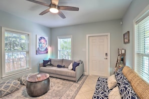 A living room with a sofa, a coffee table, and a ceiling fan.