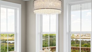 A dining area with a wooden table, white chairs, and a chandelier.