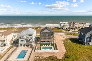 A beachfront property with multiple buildings, a swimming pool, and a view of the ocean. - Cabin by the Sea #138 - Private Pool, Second Row Oceanfront & Sound Views! (North Topsail Beach)