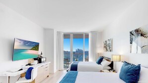 Une chambre d’hôtel moderne avec un grand lit, un bureau, une chaise et une vue sur la ville.