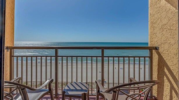 A balcony with a view of the beach, metal railings, and two chairs. - Ocean Front 1BR - Caravelle 1036 (Myrtle Beach)