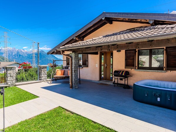 Una casa con un patio, un jacuzzi y vistas a las montañas.