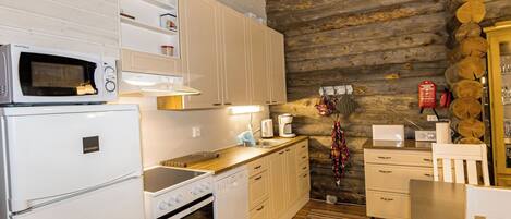 Een koelkast, een magnetron, een vaatwasser, kookgerei, borden en bestek